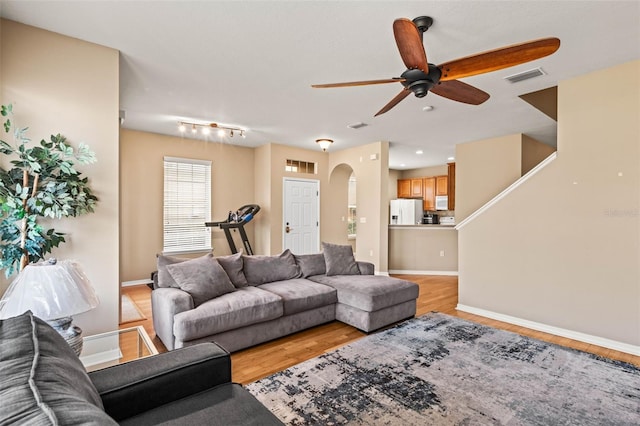 living room featuring ceiling fan and light wood-type flooring