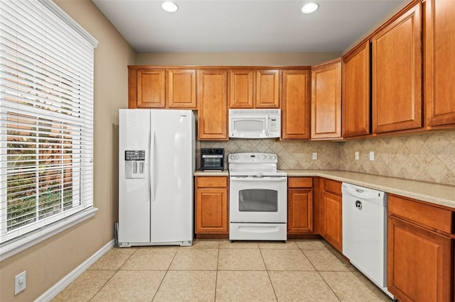 kitchen with light tile patterned flooring, decorative backsplash, and white appliances