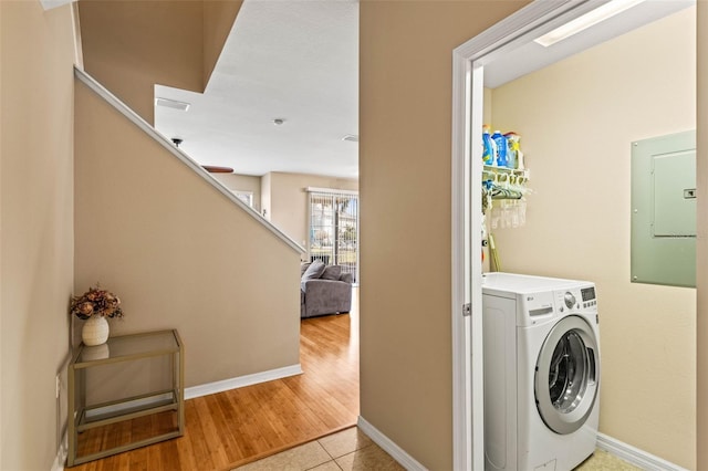 laundry area featuring washer / dryer, light tile patterned floors, and electric panel