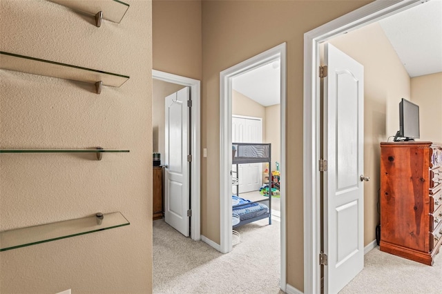 hallway featuring light colored carpet and vaulted ceiling