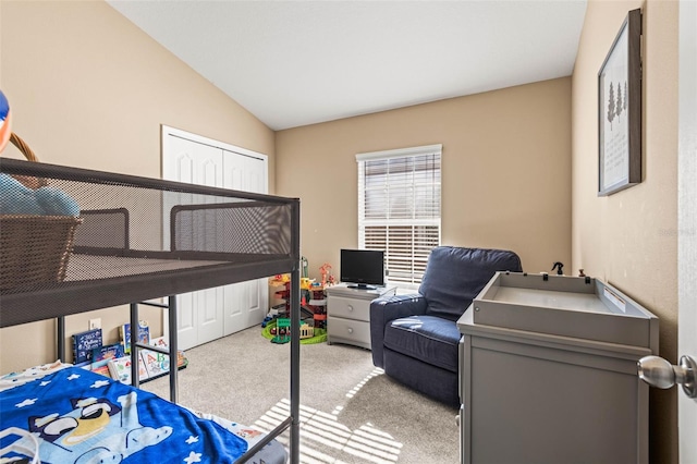 carpeted bedroom featuring a closet and lofted ceiling