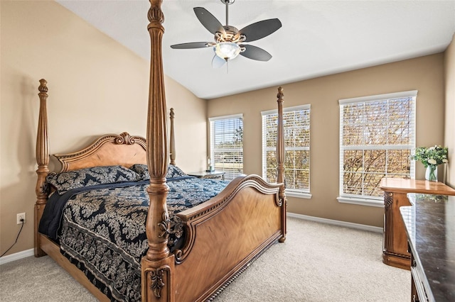 carpeted bedroom with ceiling fan, multiple windows, and lofted ceiling