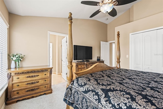 carpeted bedroom with ceiling fan, a closet, and lofted ceiling