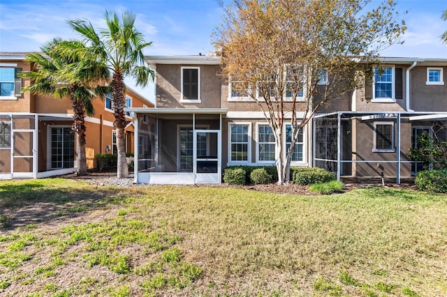 rear view of property featuring a sunroom and a yard