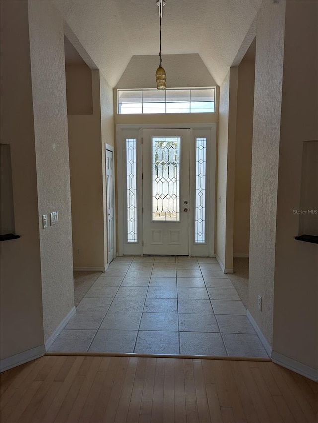 foyer featuring high vaulted ceiling and light wood-type flooring