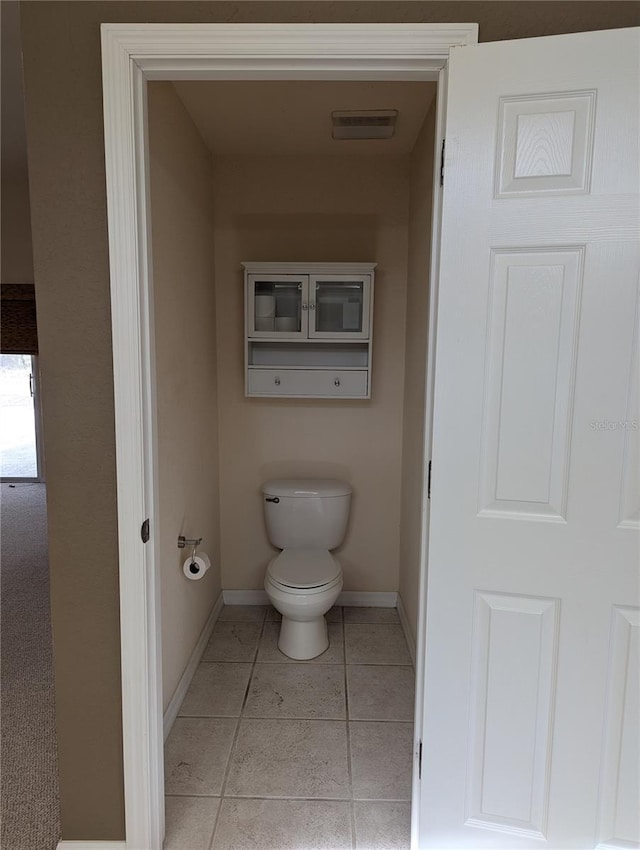 bathroom featuring toilet and tile patterned flooring