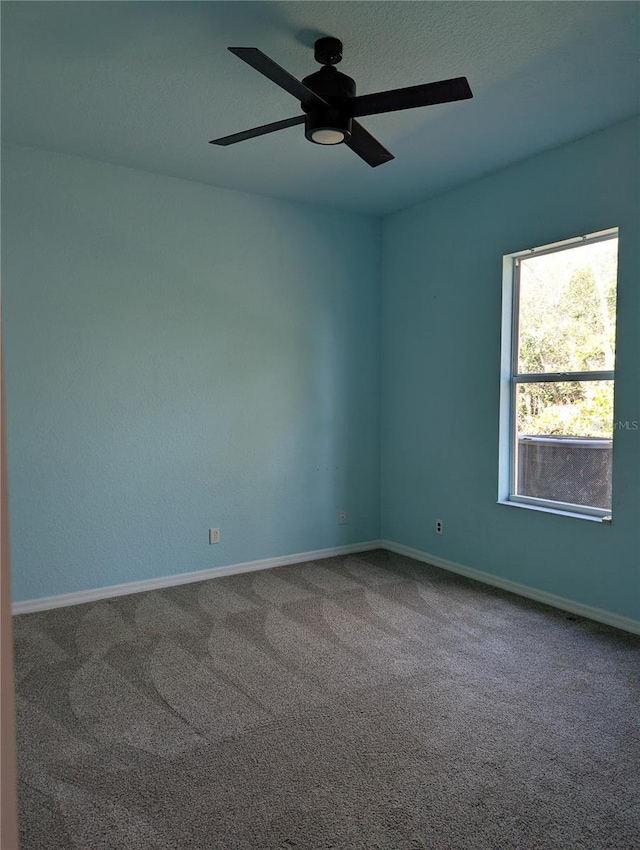 spare room with ceiling fan and carpet