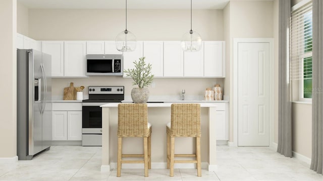 kitchen with stainless steel appliances, white cabinets, hanging light fixtures, and a kitchen bar