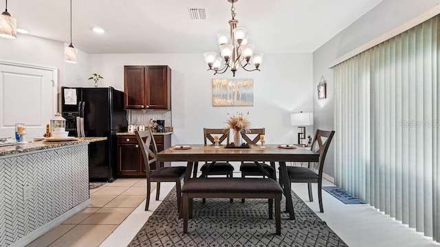 tiled dining room with a notable chandelier