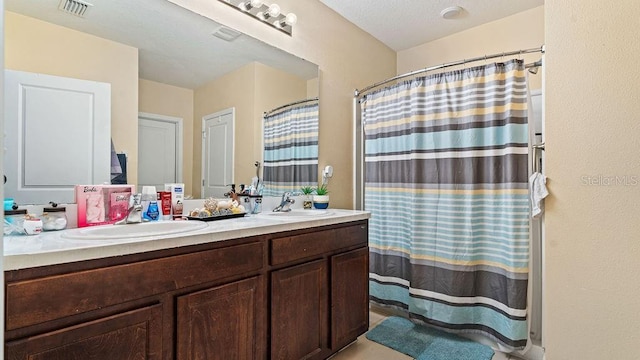 bathroom featuring a textured ceiling, a shower with shower curtain, and vanity