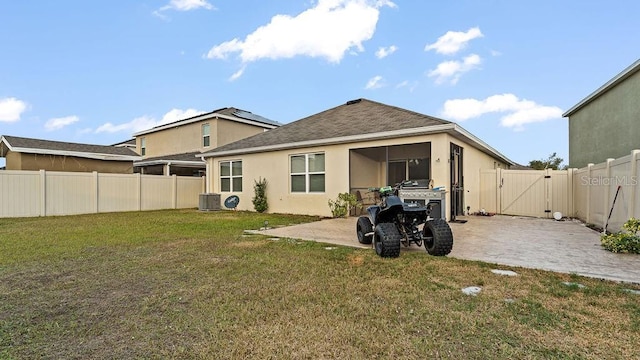 rear view of property with central air condition unit, a patio, and a lawn