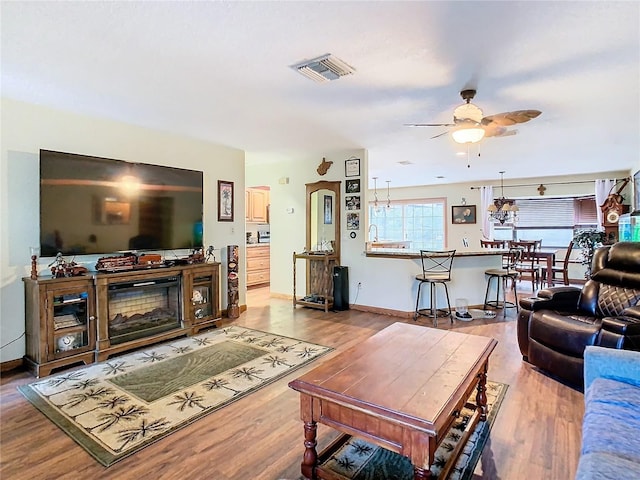 living room featuring ceiling fan and light hardwood / wood-style floors