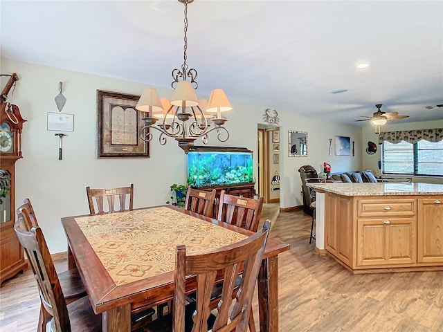 dining area featuring ceiling fan with notable chandelier and light wood-type flooring