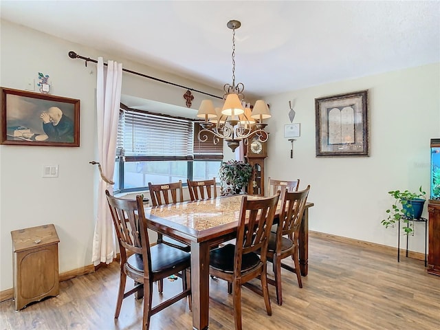 dining room with hardwood / wood-style floors and a notable chandelier