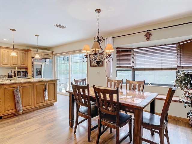 dining area featuring a chandelier and light hardwood / wood-style floors