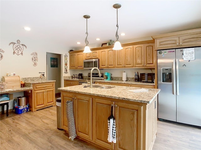 kitchen with appliances with stainless steel finishes, light hardwood / wood-style flooring, a center island with sink, and sink