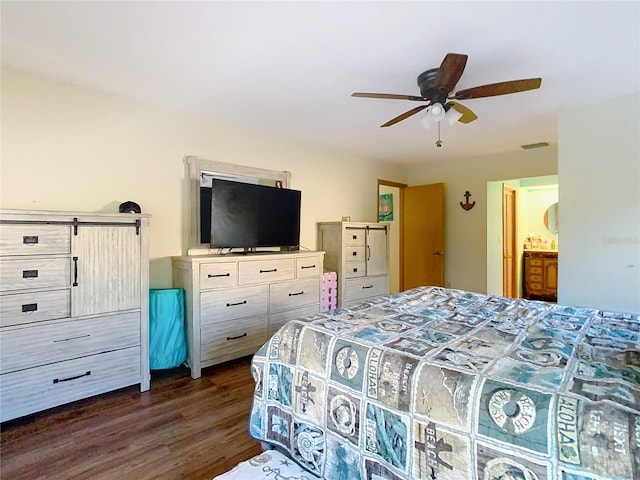 bedroom featuring ceiling fan, ensuite bathroom, and dark hardwood / wood-style floors