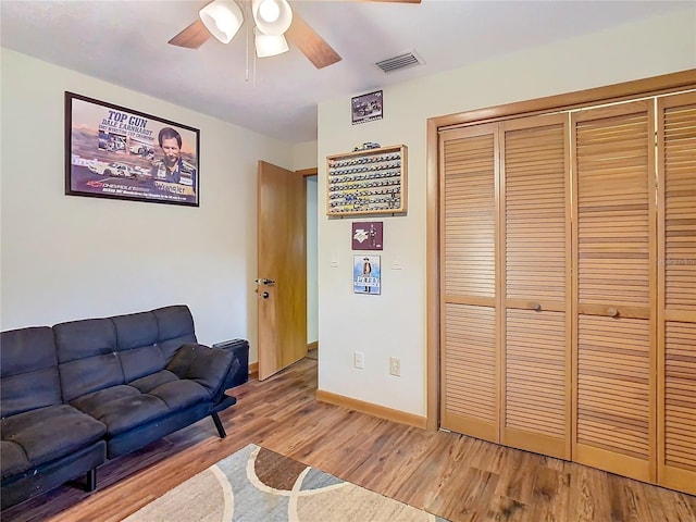 living room with hardwood / wood-style flooring and ceiling fan