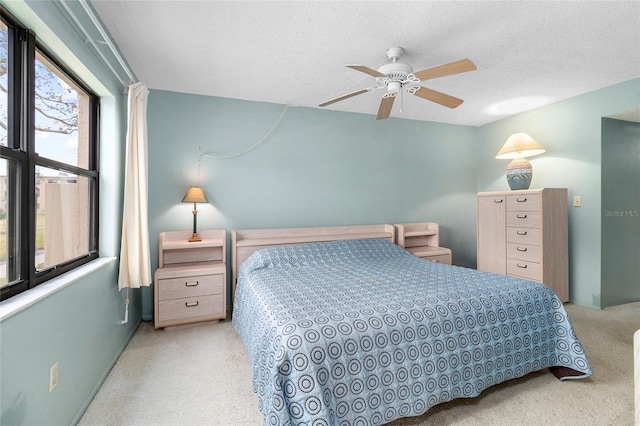 bedroom with ceiling fan and a textured ceiling