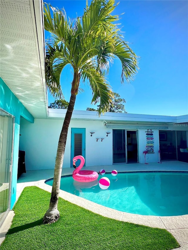 view of swimming pool with a lawn