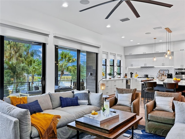 living area featuring recessed lighting, visible vents, and a ceiling fan