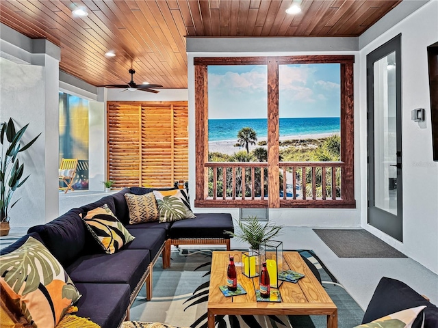 living room featuring wooden ceiling, recessed lighting, a water view, and a view of the beach