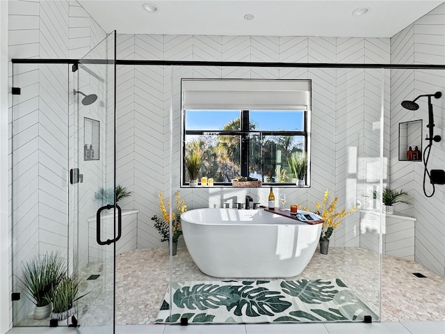 full bath featuring recessed lighting, a freestanding bath, tile walls, and a shower stall