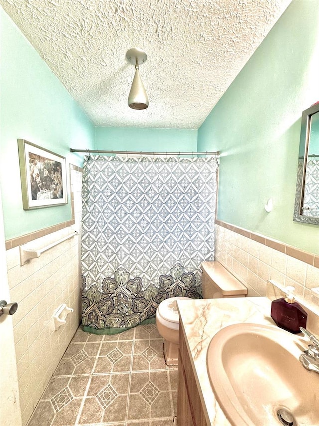 bathroom featuring vanity, tile walls, and a textured ceiling