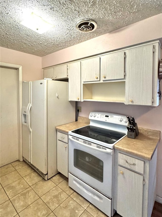 kitchen featuring light tile patterned floors and white appliances