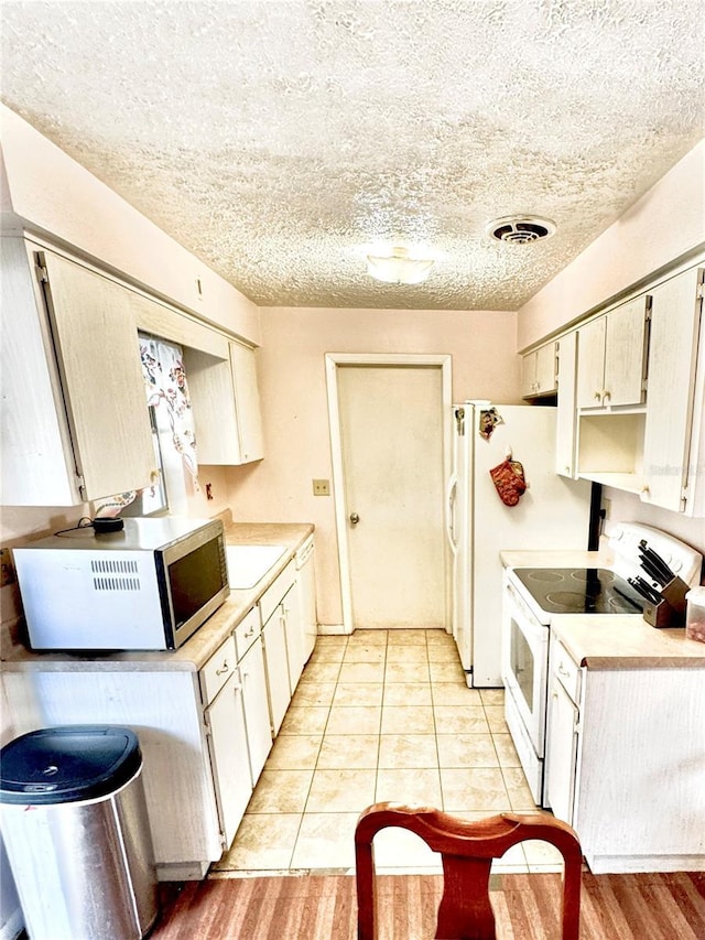 kitchen with light tile patterned floors, sink, and white appliances