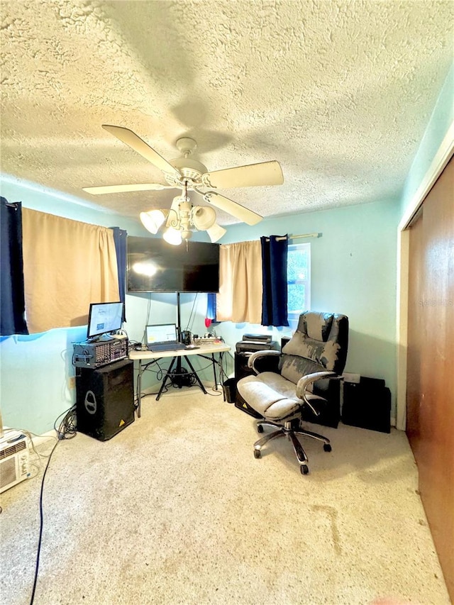 carpeted office featuring a textured ceiling and ceiling fan