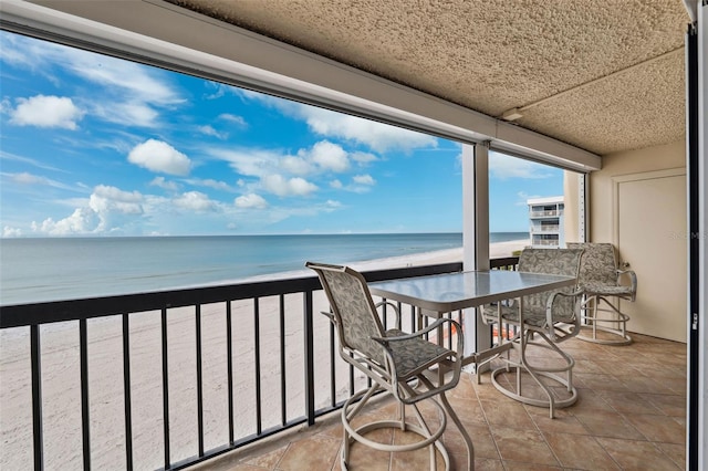 balcony featuring a water view and a view of the beach