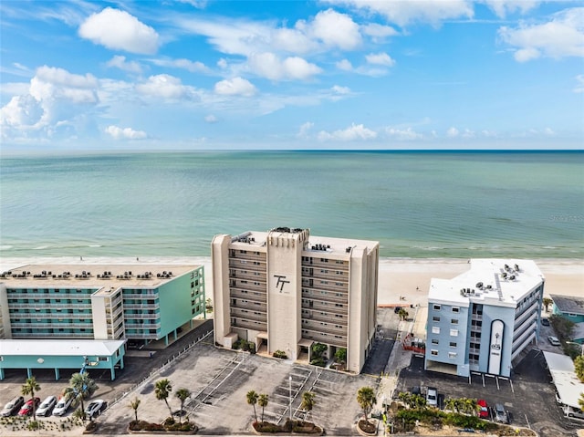 birds eye view of property with a water view and a beach view