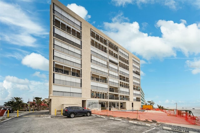 view of building exterior with uncovered parking