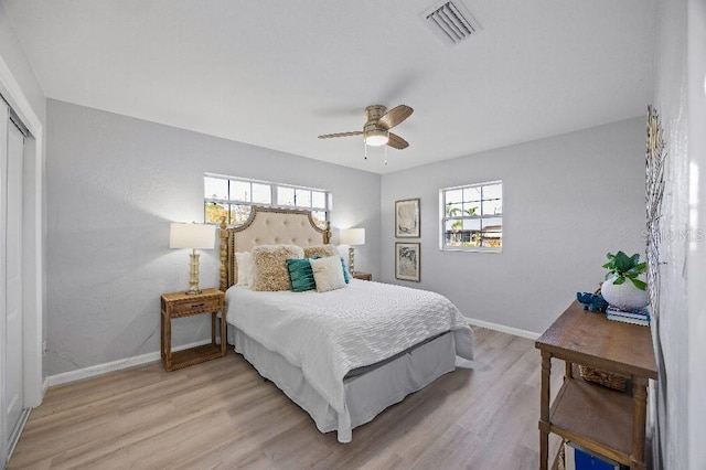 bedroom with ceiling fan, a closet, and light hardwood / wood-style flooring