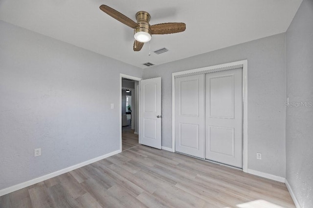 unfurnished bedroom featuring light wood-type flooring, ceiling fan, and a closet