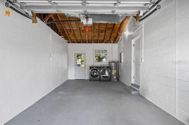 garage with electric water heater, a garage door opener, and separate washer and dryer