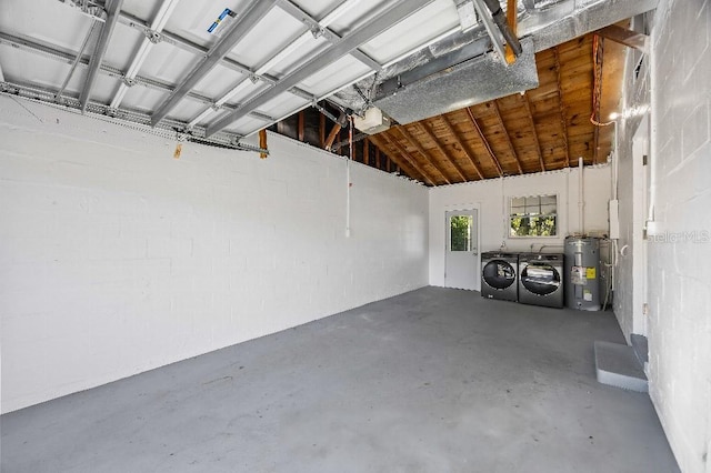 garage with electric water heater, a garage door opener, and washing machine and clothes dryer