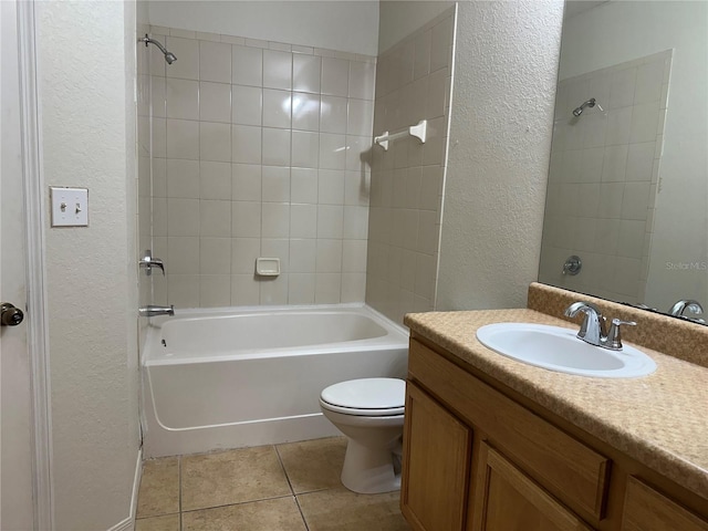 full bathroom with toilet, tiled shower / bath combo, tile patterned flooring, and vanity