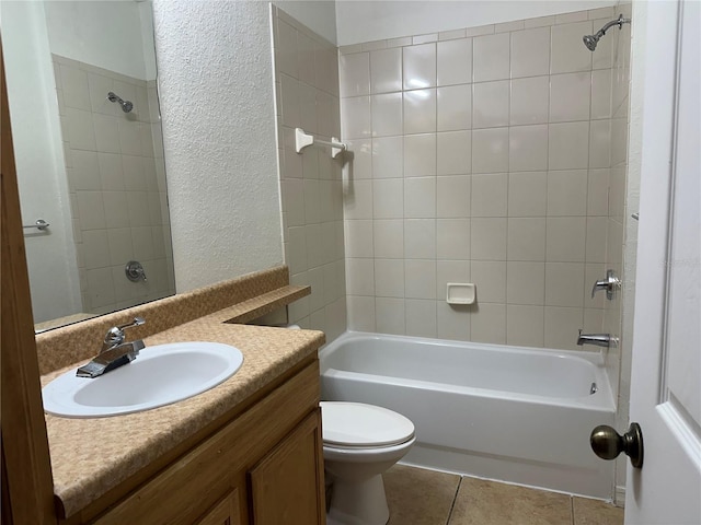 full bathroom with vanity, tiled shower / bath combo, tile patterned floors, and toilet