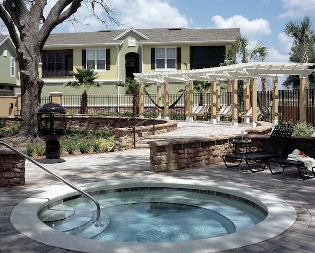 exterior space with a community hot tub, a pergola, and a patio