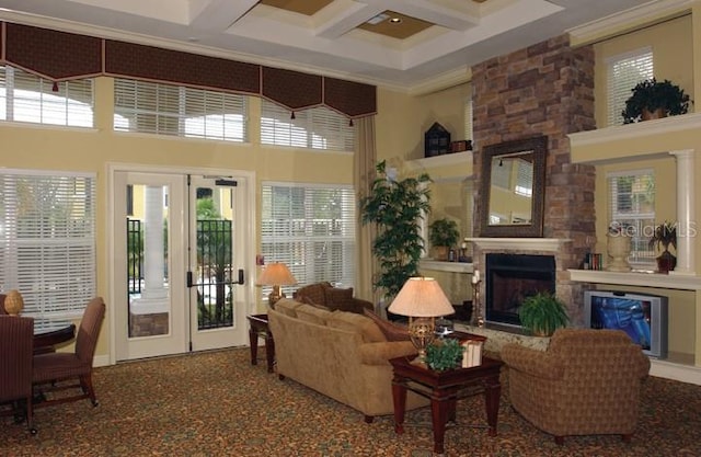 living room with a towering ceiling, french doors, coffered ceiling, and a stone fireplace