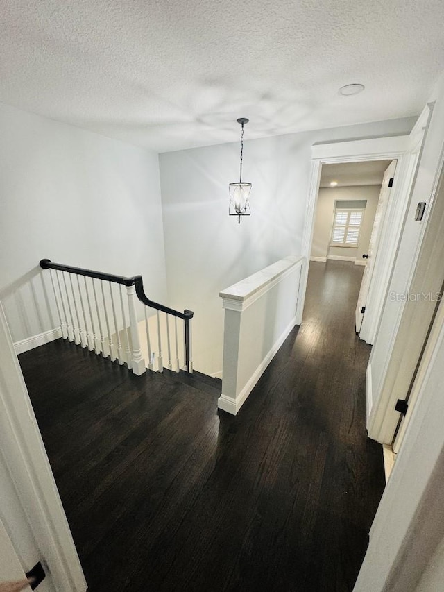 corridor featuring dark hardwood / wood-style floors and a textured ceiling