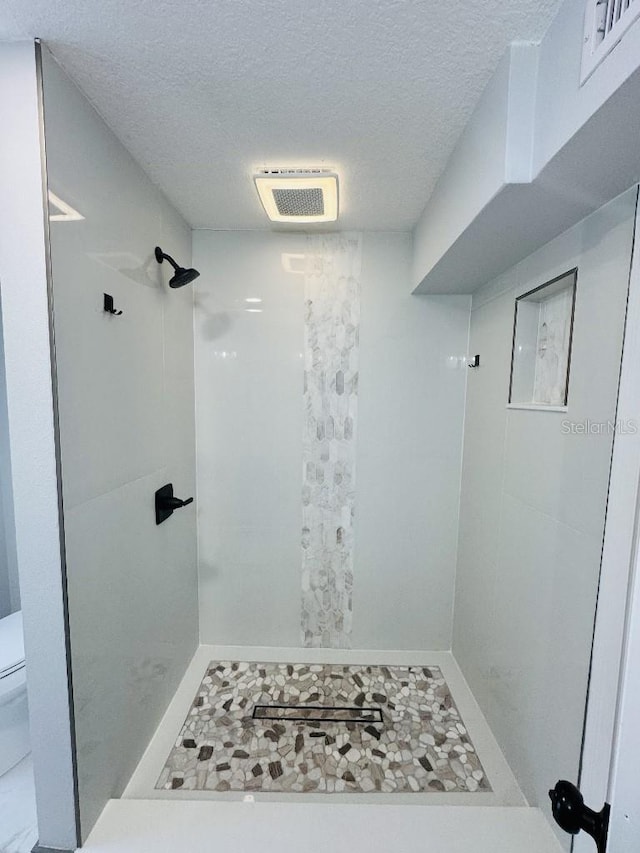 bathroom with a textured ceiling and walk in shower