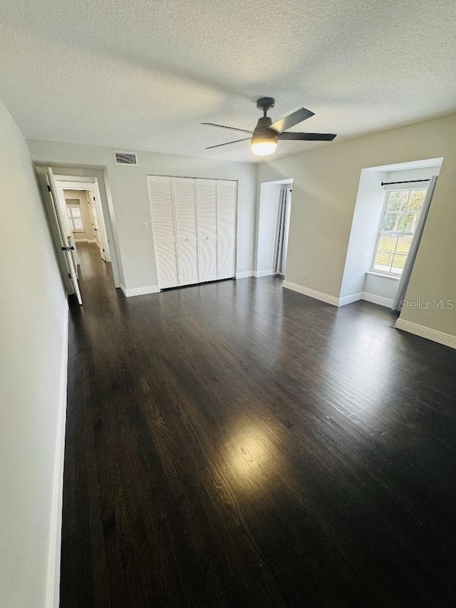 unfurnished bedroom featuring a textured ceiling, dark hardwood / wood-style floors, and ceiling fan