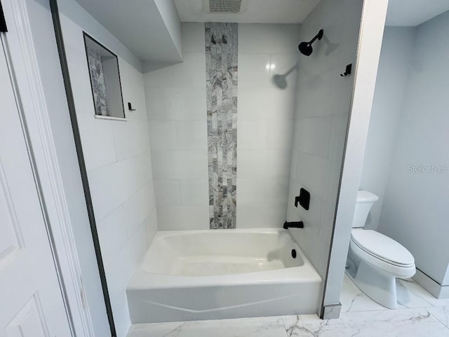 bathroom with toilet and tiled shower / bath