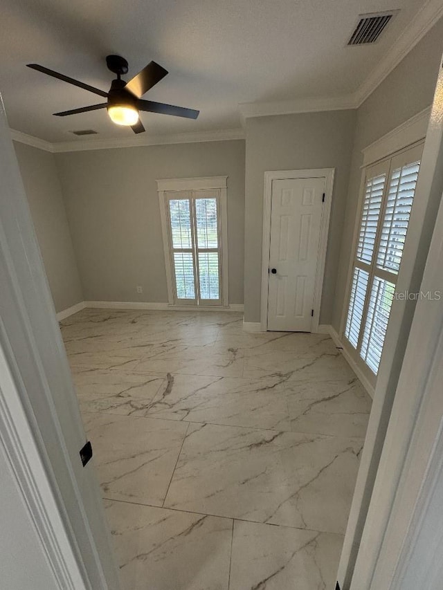 spare room featuring ornamental molding and ceiling fan