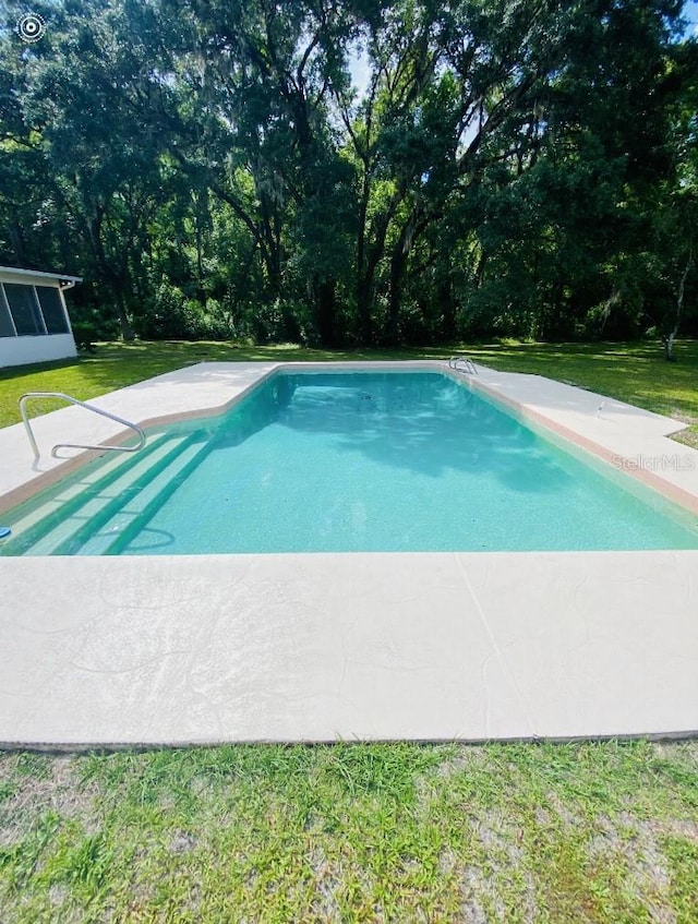 view of swimming pool featuring a lawn