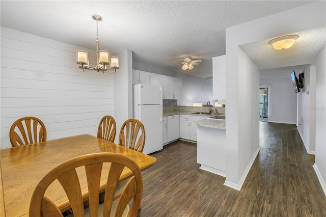 kitchen with dark wood finished floors, light countertops, white cabinets, a textured ceiling, and white appliances