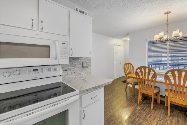 kitchen with dark wood finished floors, visible vents, backsplash, a textured ceiling, and white appliances